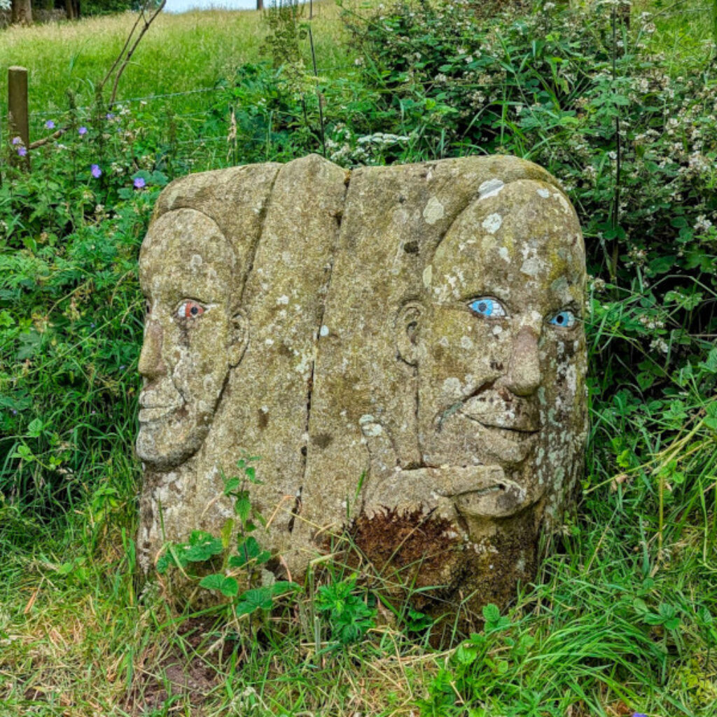 a carved rock with two faces with painted eyes