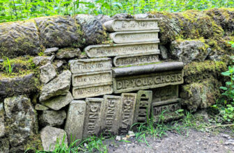 a stack of books carved out of stone embedded into a stone wall