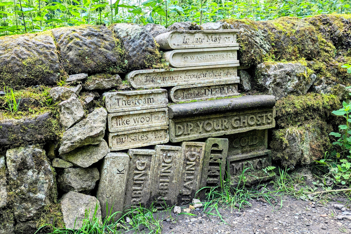 a stack of books carved out of stone embedded into a stone wall