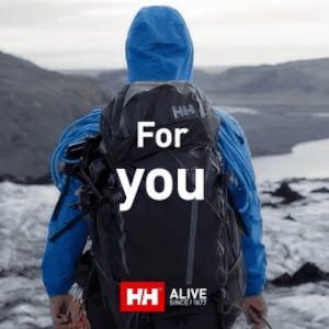 Helly Hanson clothing on a man in a blue waterproof jacket walking on a glacier