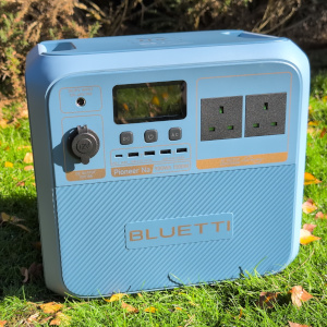 the Bluetti Pioneer Na power station sitting on the grass with full view of its front control panel