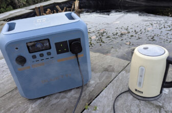 a Bluetti Pioneer Na power station next to a boiling kettle. there is ice and frost on the ground on a winters day