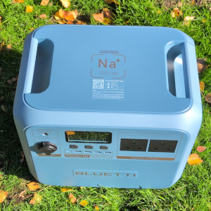 the Bluetti Pioneer Na power station sitting on the grass with full view of its top charging panel